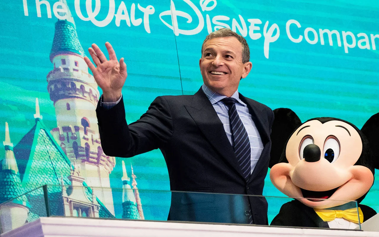 Robert Iger besides a micky mascot