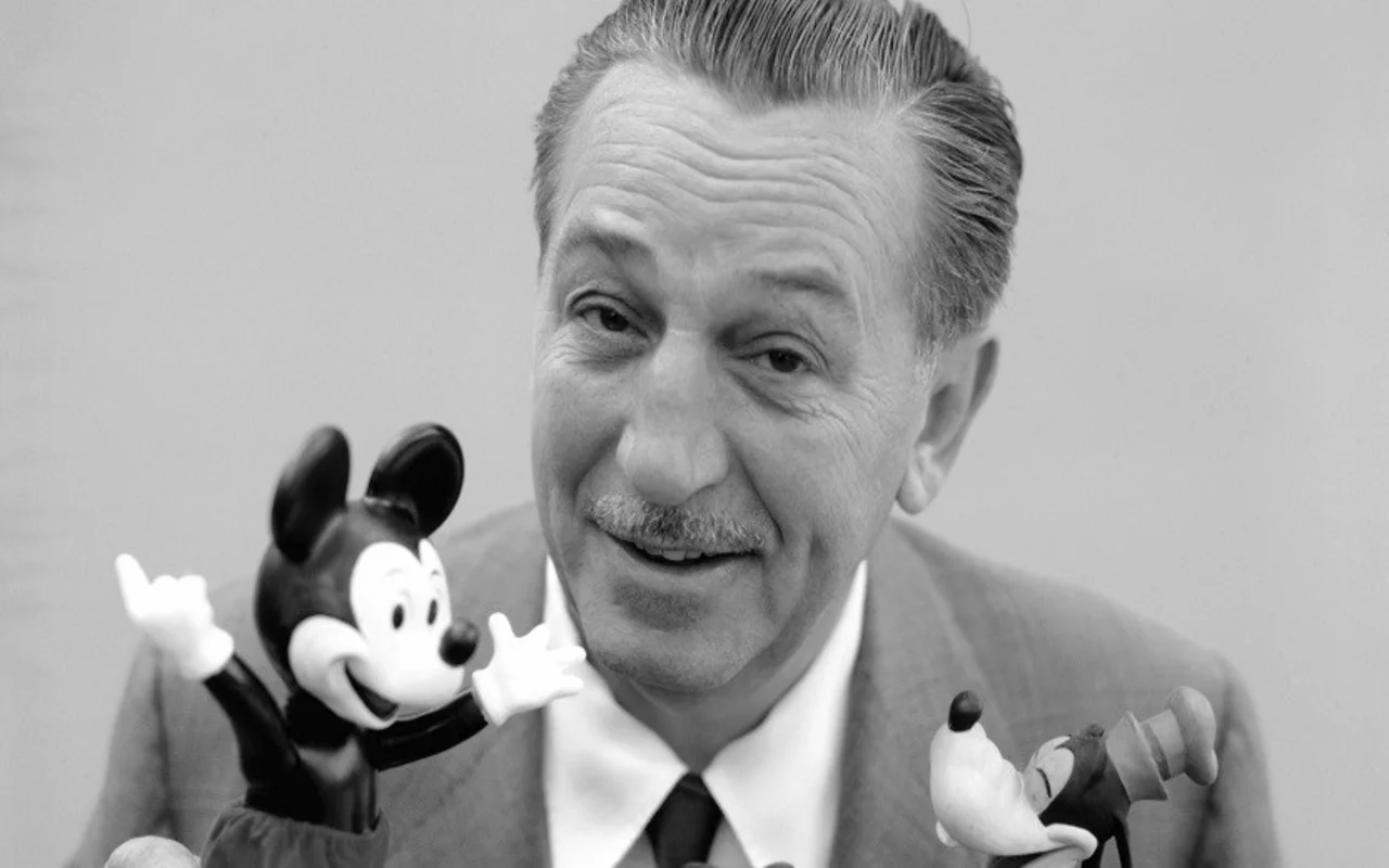 a picture of Walt Disney holding figures of Micky Mouse & Goofy